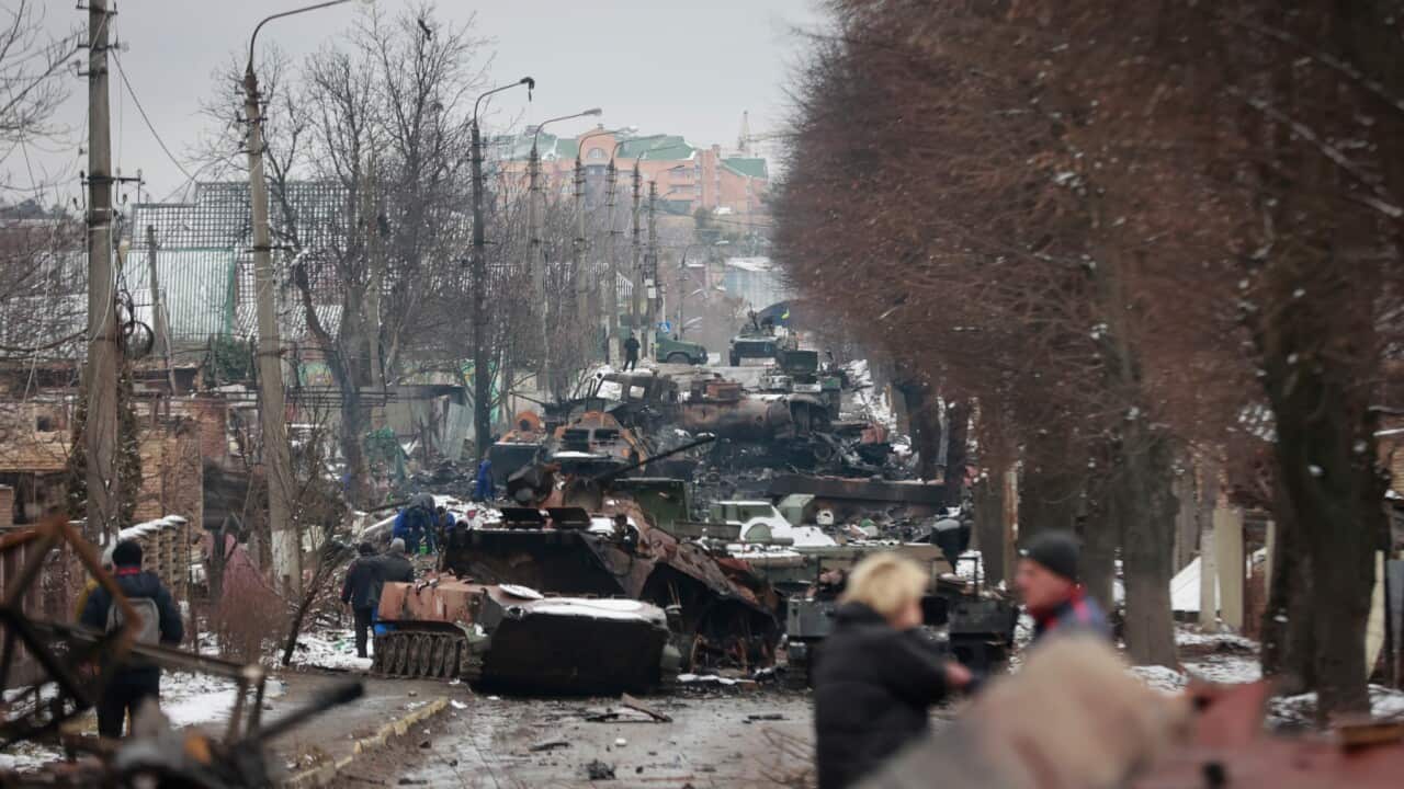 People look at the gutted remains of Russian military vehicles on a road in the town of Bucha, close to the capital Kyiv, Ukraine, Tuesday, March 1, 2022