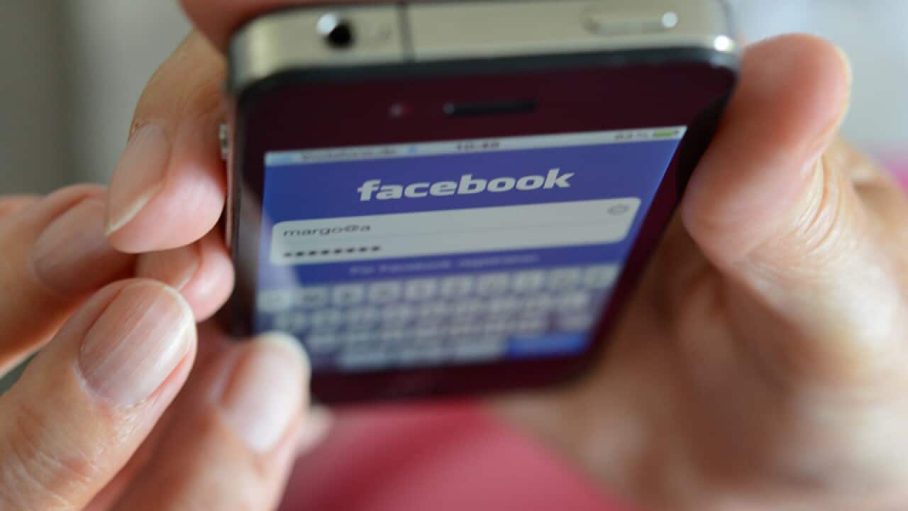 A woman uses Facebook on her smartphone