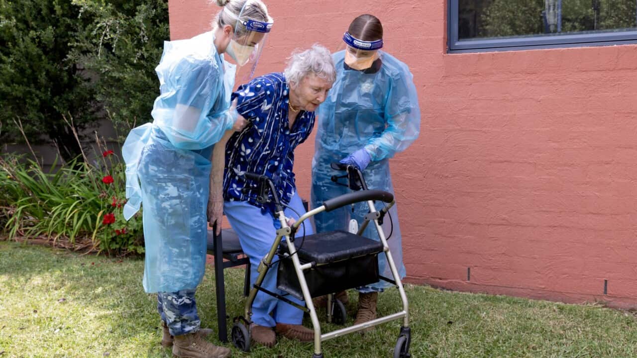 A supplied image obtained on Friday, February 25, 2022 shows Royal Australian Air Force medics Corporal Amy Hutchison (left) and Aircraftwoman Laura Millen assisting aged-care resident Ms Gwen Metcalf at an aged-care facility in southern New South Wales.