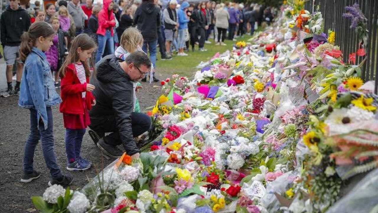 Mourners lay flowers on a wall at the Botanical Gardens in Christchurch.