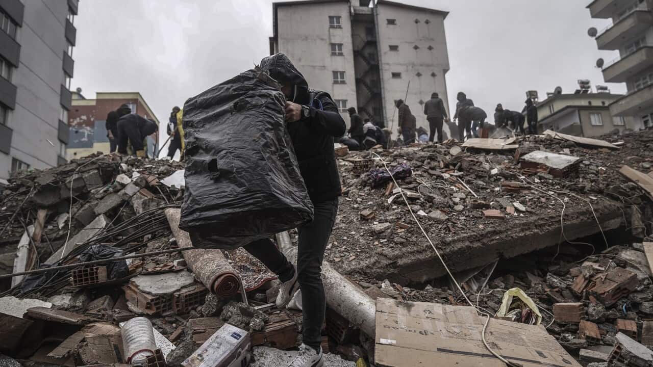 People and emergency teams search for people in the rubble in a destroyed building in Gaziantep, Turkey (AAP)