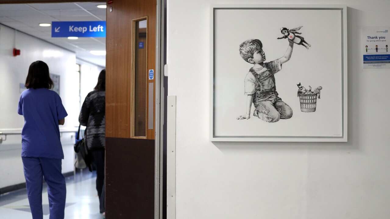A person walks past the new artwork painted by Banksy during lockdown, entitled 'Game Changer', which has gone on display to staff and patients on Level C of Southampton General Hospital.. Picture date: Thursday May 7, 2020. See PA story ARTS Banksy. 
