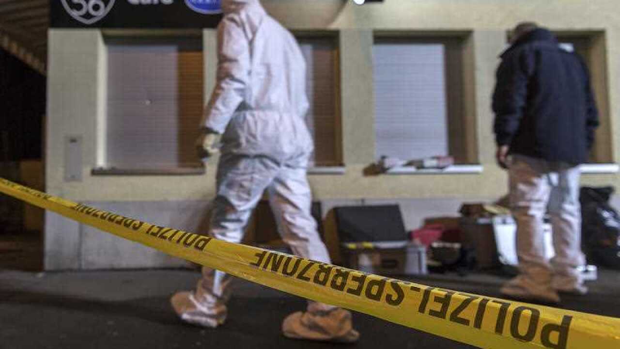 A forensic team investigates the scene after a deadly gunfire in a coffee bar