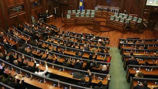 An image of people with right hands raised in Kosovo's parliament.