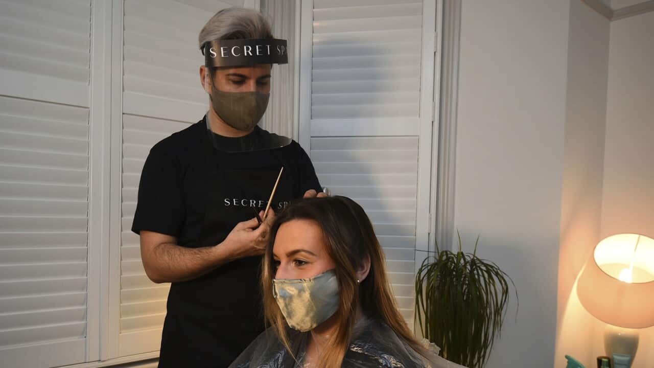 A hair stylist cuts the hair of Amy Pallister just after midnight on Monday at the end of lockdown