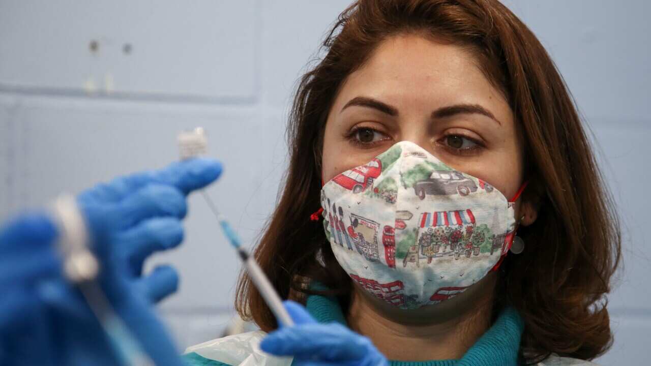 A healthcare worker preparing to administer a COVID-19 vaccination.