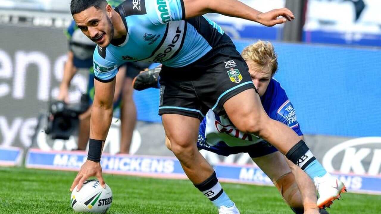 Valentine Holmes of the Sharks scores a try against the Bulldogs.