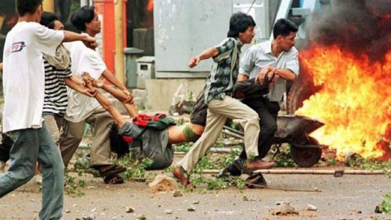 A man allegedly shot by police is carried following clashes in Jakarta in 1998.