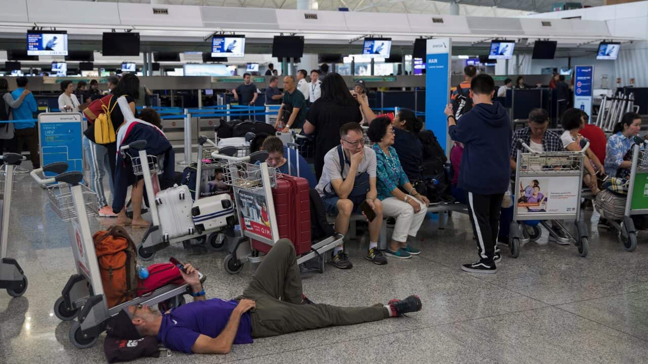 Stranded travelers wait in the departure hall of the Hong Kong International Airport in Hong Kong.