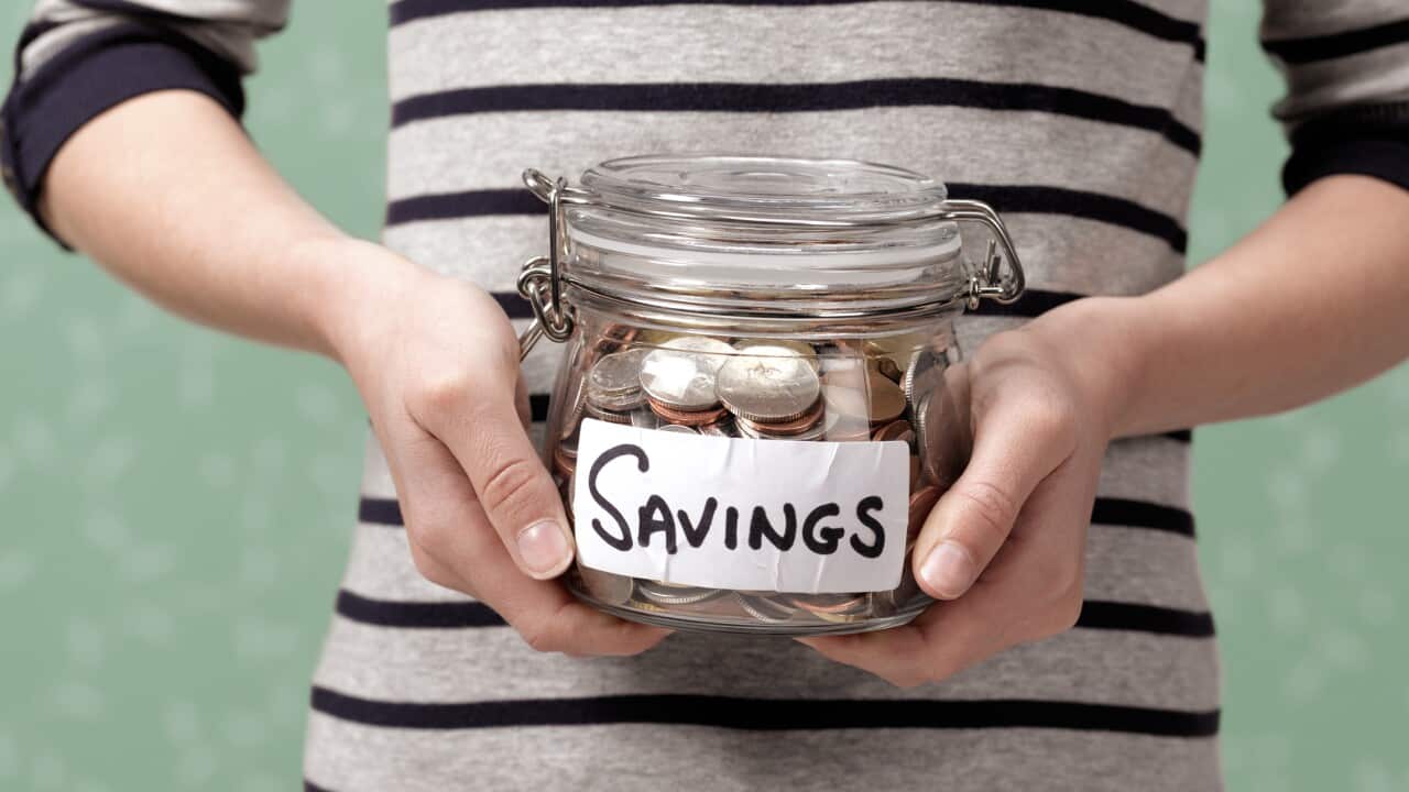 10 year old holding savings in jar