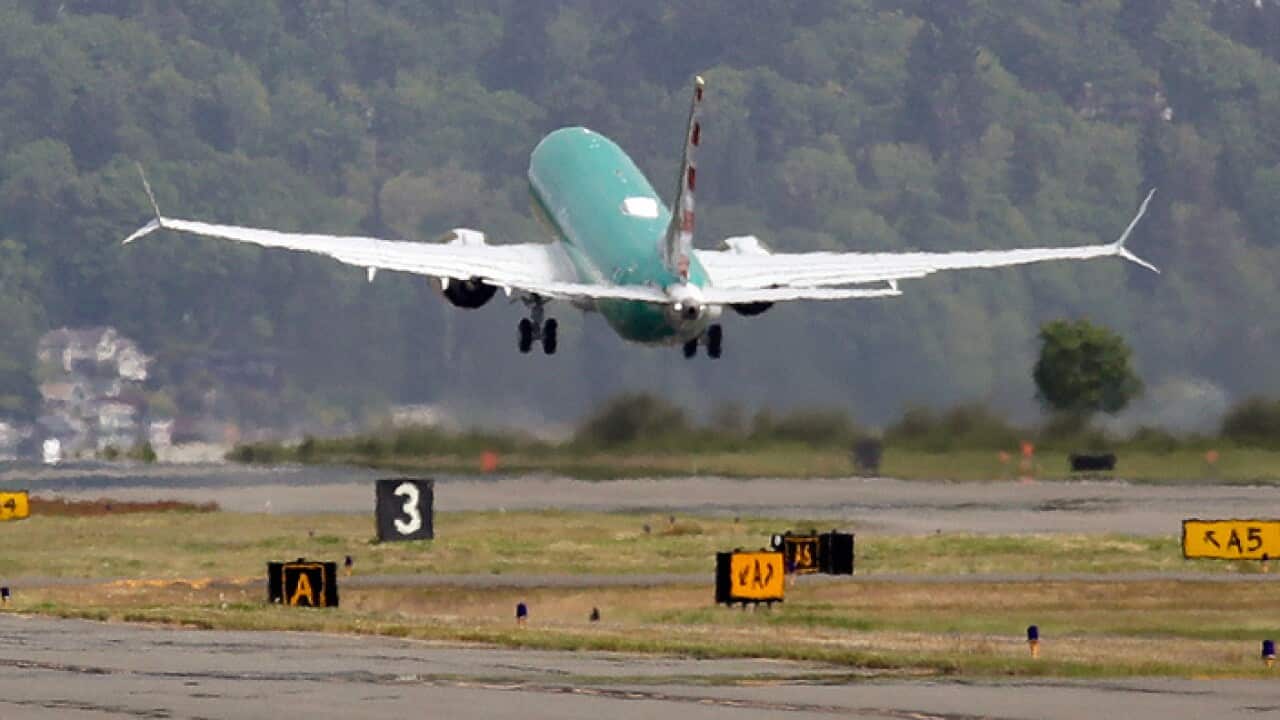 A Boeing 737 MAX 8 is partially obscured by the engine wash as it takes-off on a test flight