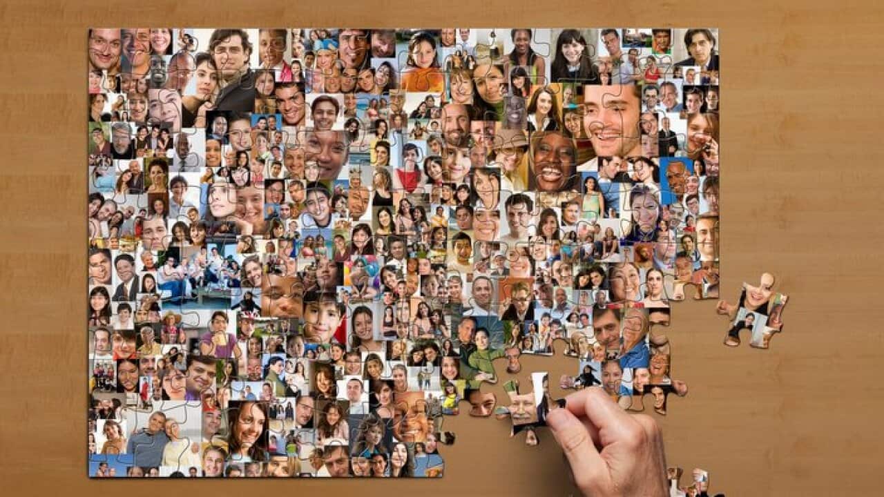 Businessman assembling puzzle of collage of smiling face