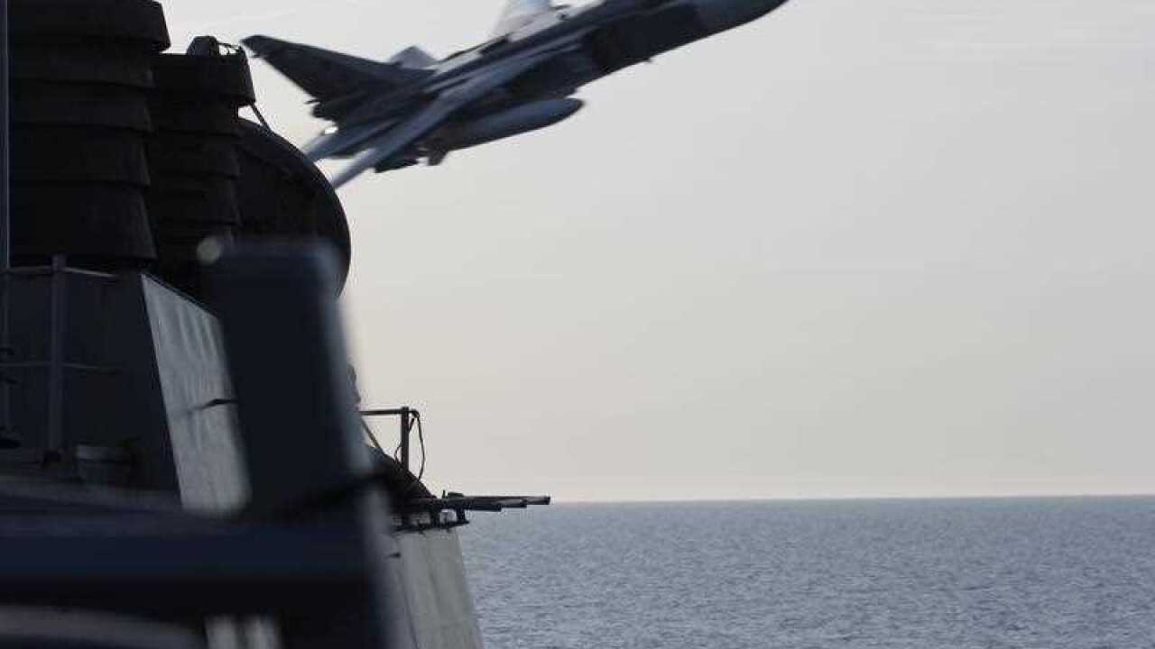 In this image released by the U.S. Navy, a Russian SU-24 jet makes a close-range and low altitude pass near the USS Donald Cook on Tuesday, April 12
