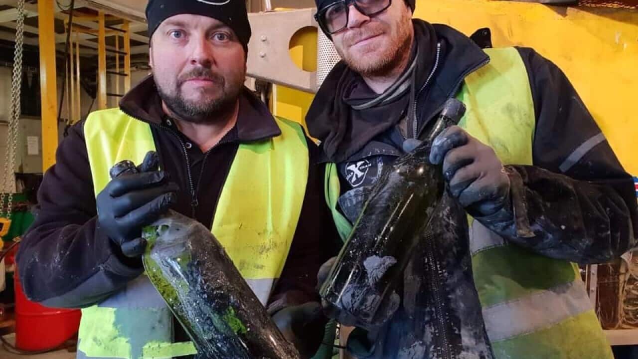 Peter Linberg and another Ocean X team member with two of the bottles of cognac.