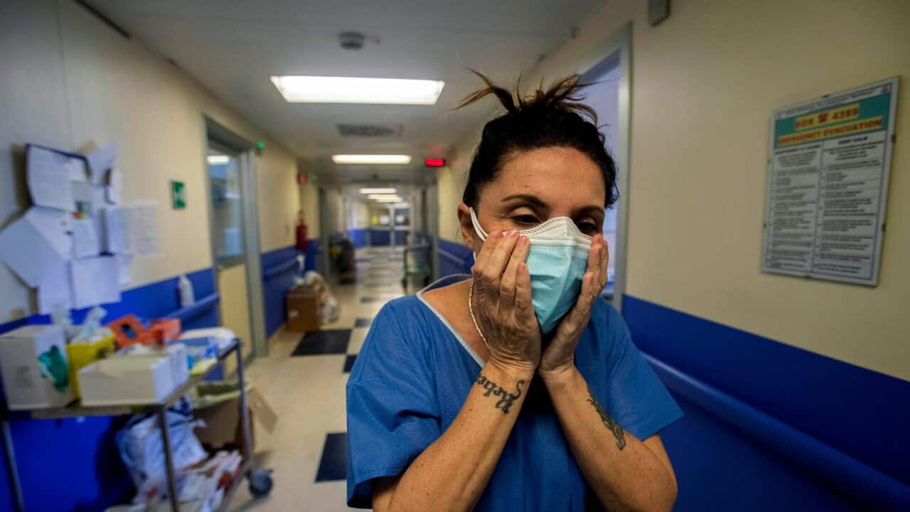 Nurse Cristina Settembrese fixes two masks to her face during her work shift in the COVID-19 ward at the San Paolo hospital in Milan, Italy, April, 2020.