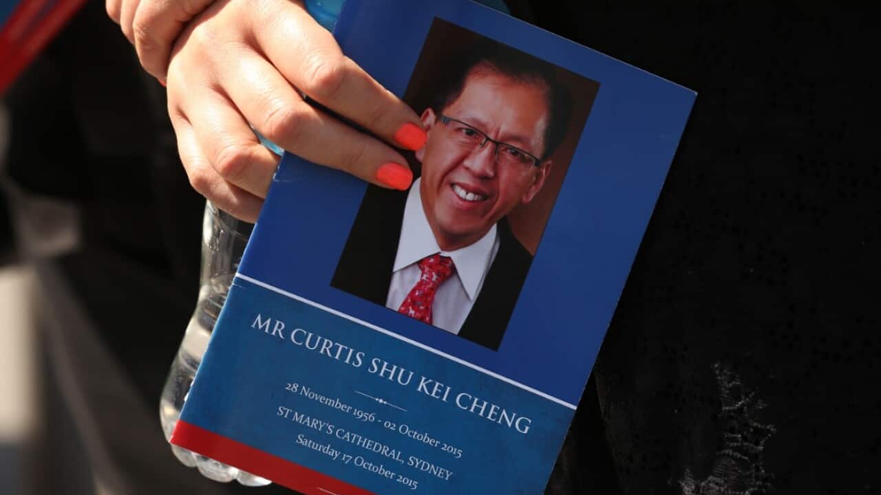 A woman holds an order of service for Curtis Cheng after his funeral service at St Mary's Cathedral, Sydney. Saturday, Oct. 17, 2015.