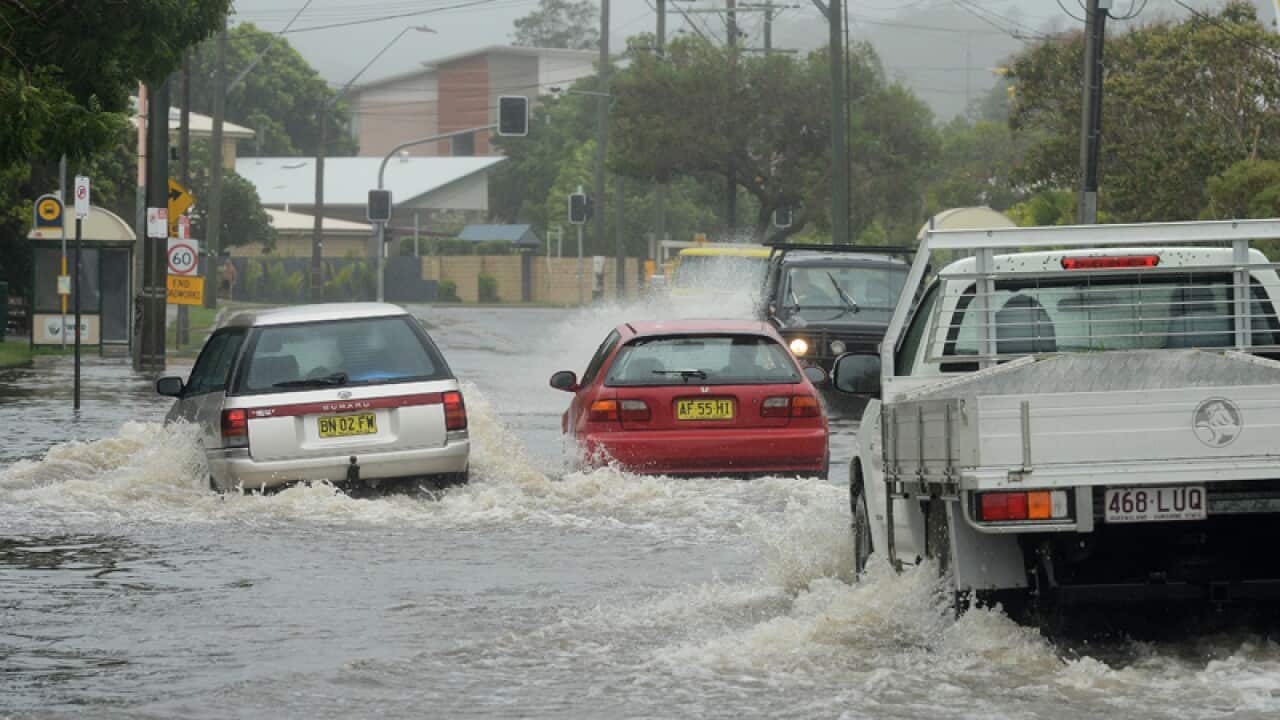 Motorists drive through a flooded waters