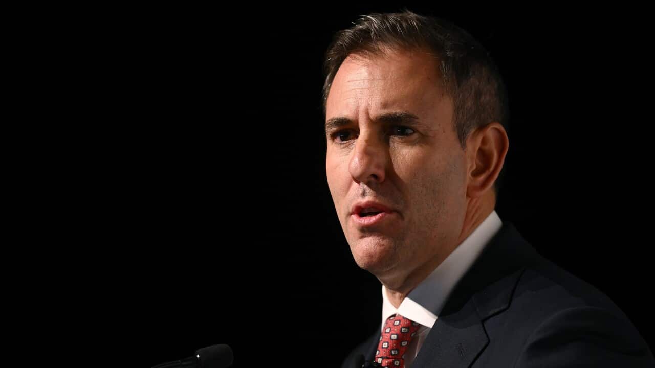 A man wearing a suit against a black background