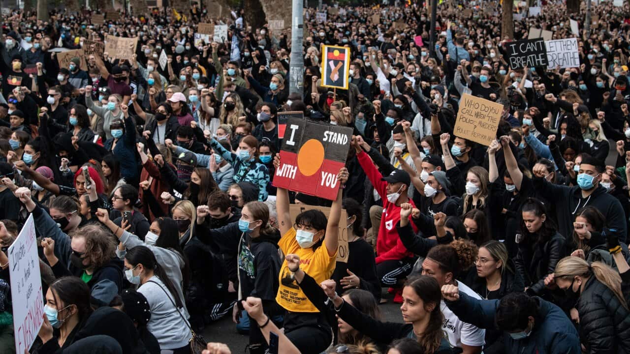 Thousands of protesters kneel and salute at a Black Lives Matter rally in Sydney