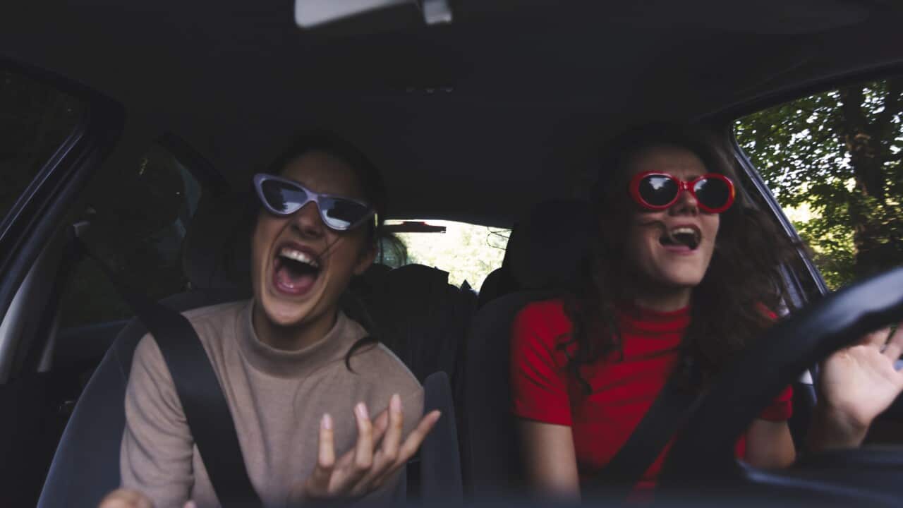 Two happy young women having fun in car