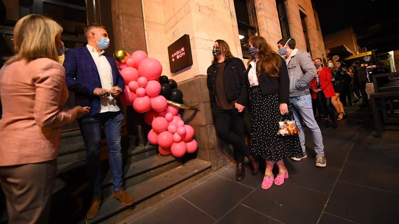 People waiting in line outside a re-opened restaurant in Melbourne