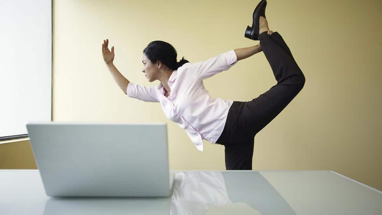 Businesswoman doing yoga in office