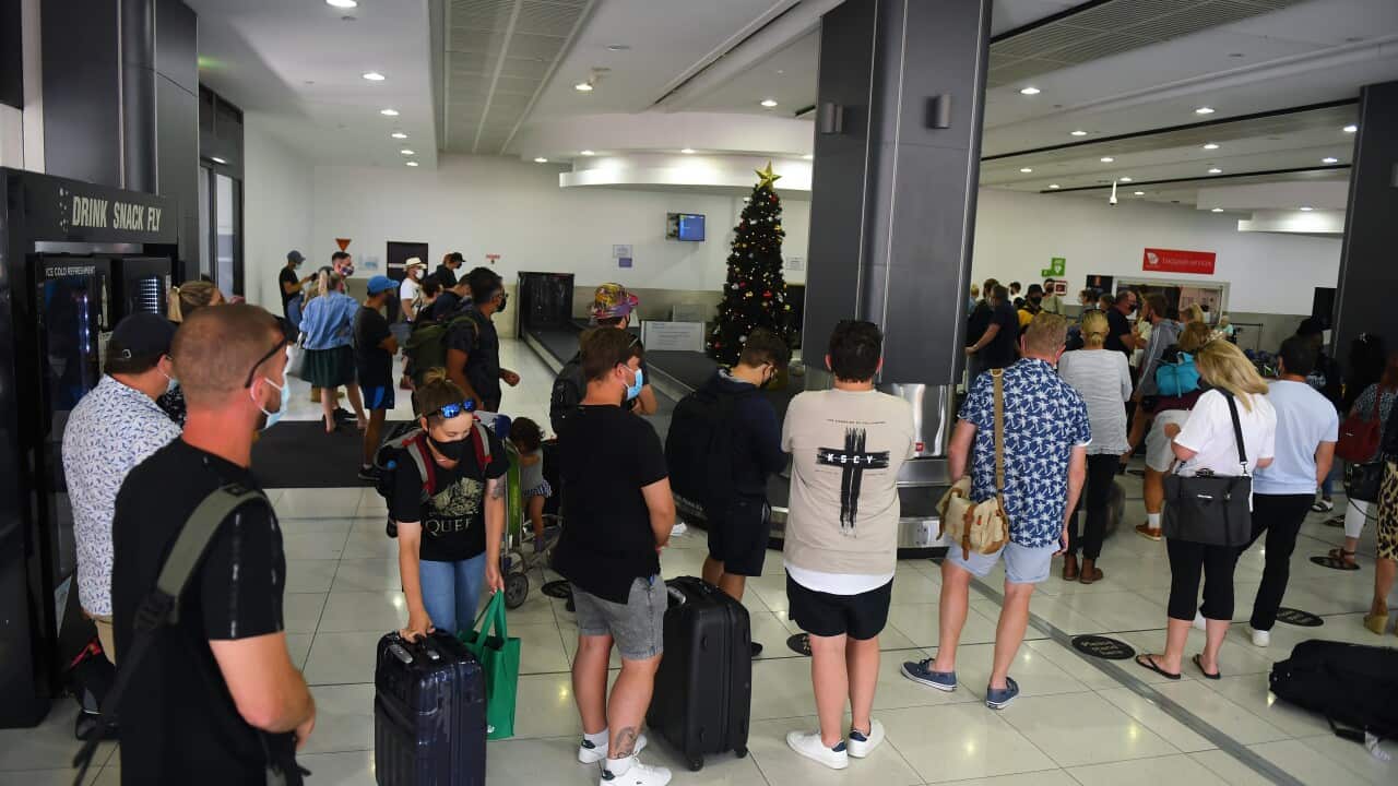 People are seen in the baggage collection area at Tullamarine Airport in Melbourne,