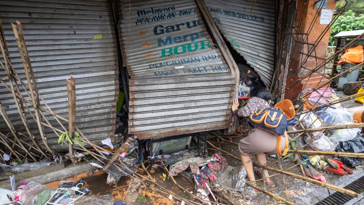 A person cleans up their shop after a flood.