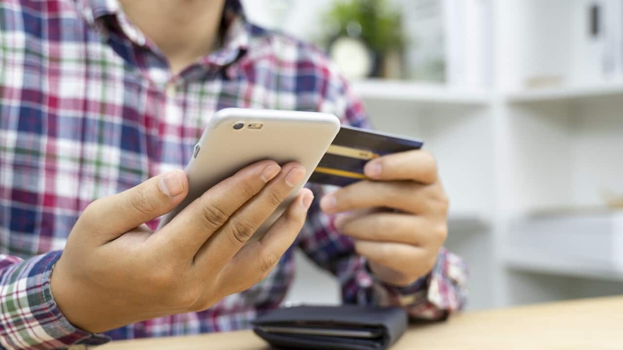Young man hands holding credit card and using phone
