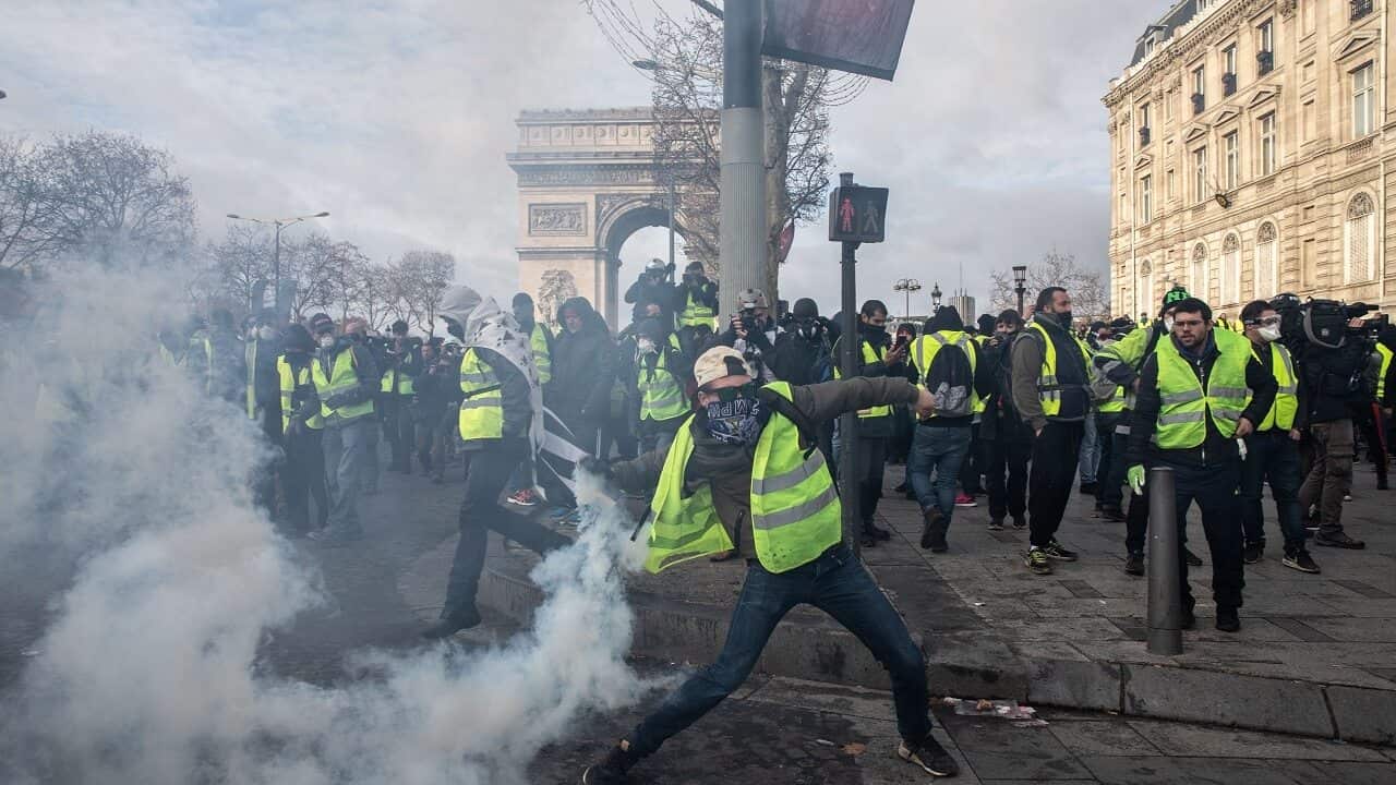 A demonstrator throws back a tear gas grenade shot by French police, during anti-government demonstrations in Paris, France, December 08, 2018.
