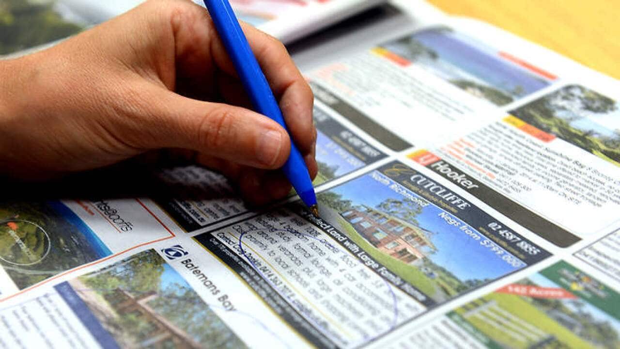 A person circles real estate advertising in a newspaper in Brisbane, Monday, Jan. 6, 2014. (AAP Image/Dan Peled) NO ARCHIVING