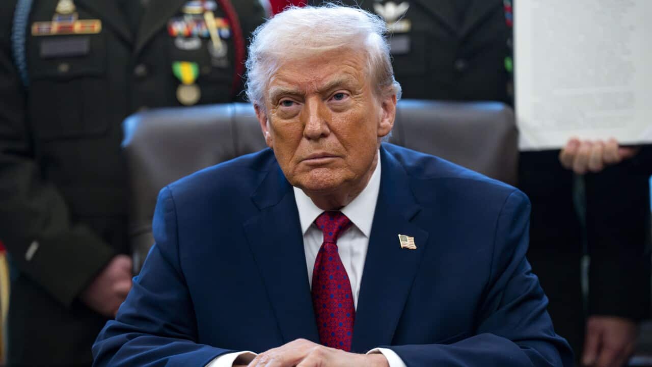 Trump sitting at a desk