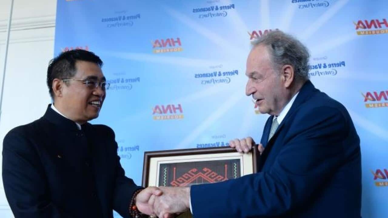 Chinese group HNA Chairman Wang Jian and Pierre et Vacances Chairman Gerard Bremond shake hands during a signing ceremony in Paris on July 4, 2016.