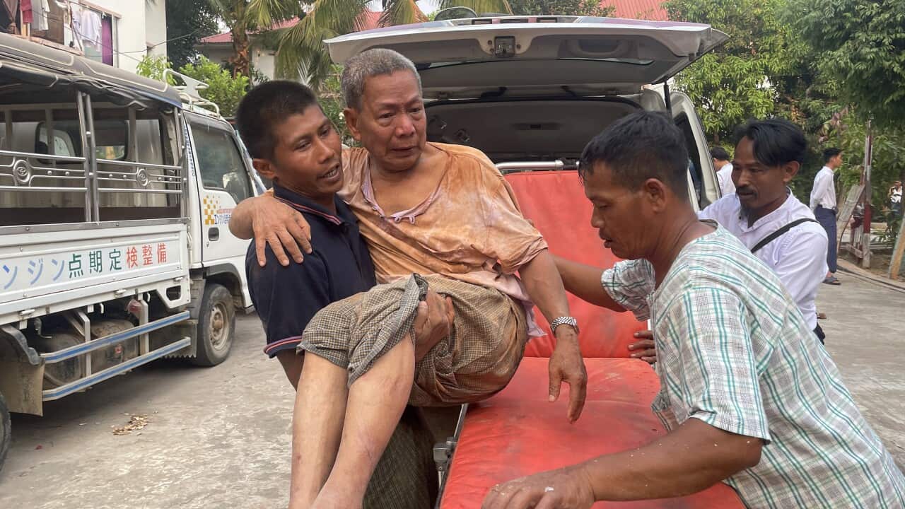 An injured man being carried onto a stretcher after the quake in Myanmar