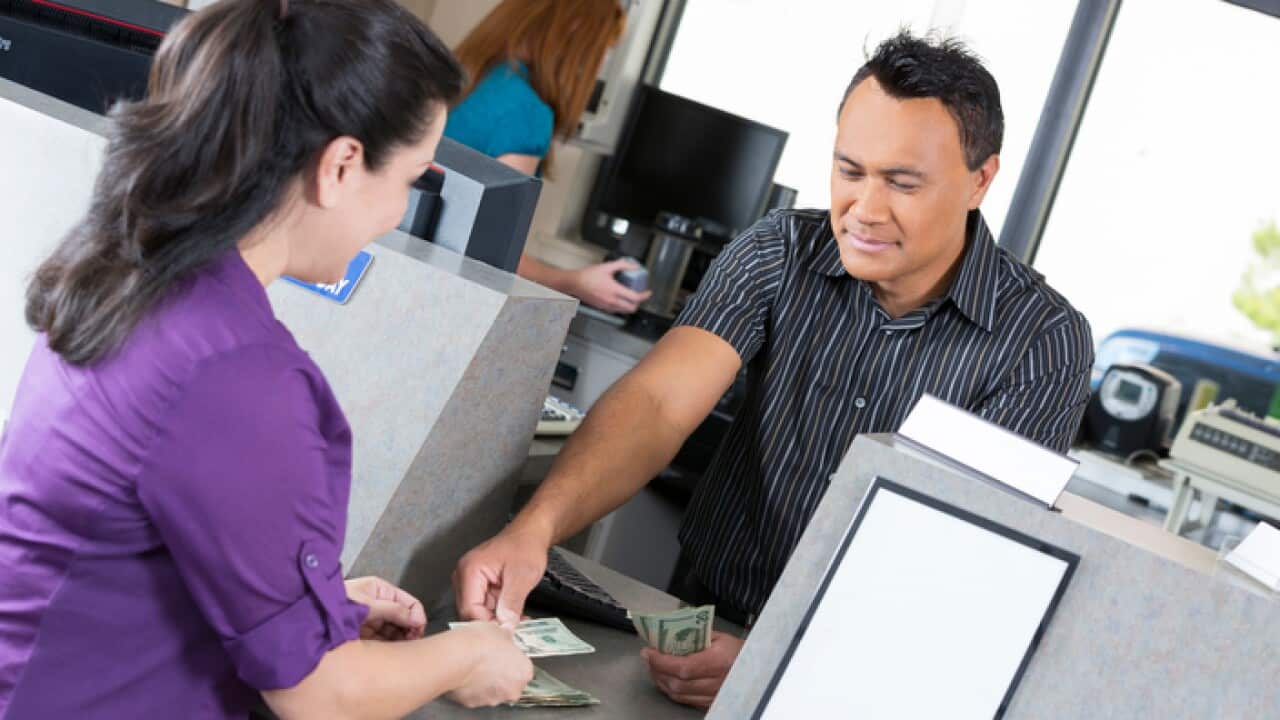 Customer at the bank getting money from teller