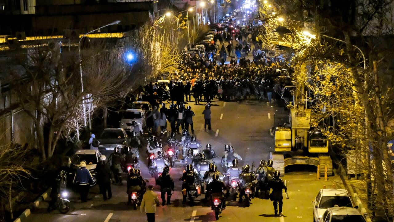 Iranian police officers take position while protesters gather in Tehran, Iran, to remember victims of a Ukrainian airplane shot down by an Iranian missile.