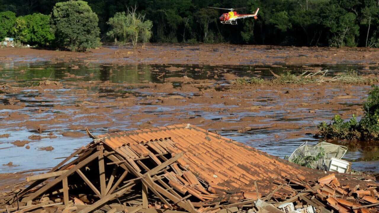 Rescue workers in a helicopter search a flooded area after a dam collapsed in Brumadinho, Brazil