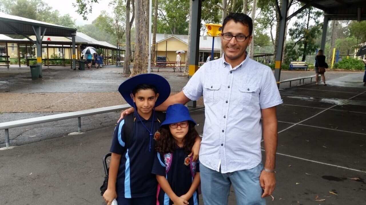 Hamid Alanizan with his children at their new school