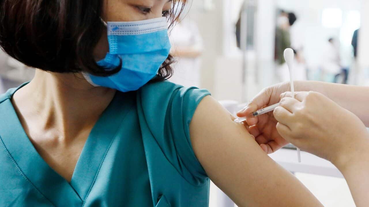 A medical worker receives a COVID-19 vaccine dose at the Thanh Nhan hospital in Hanoi, Vietnam.