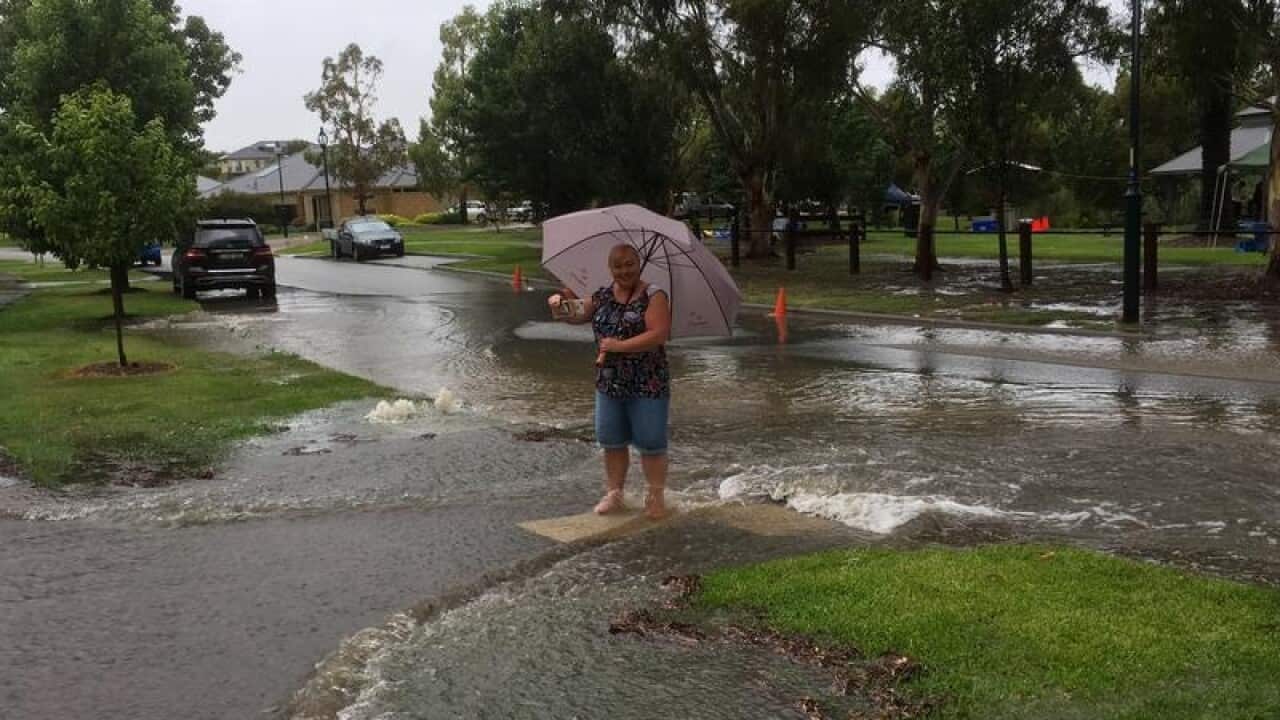 Pakenham resident Samantha Thorpe standing in her flooded driveway.