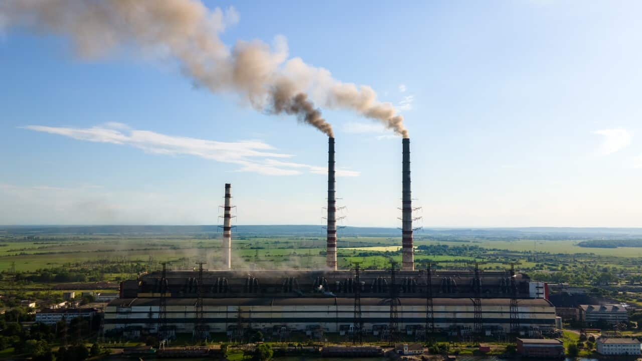 Aerial view of coal power plant high pipes with black smokestack polluting atmosphere. Electricity production with fossil fuel concept.