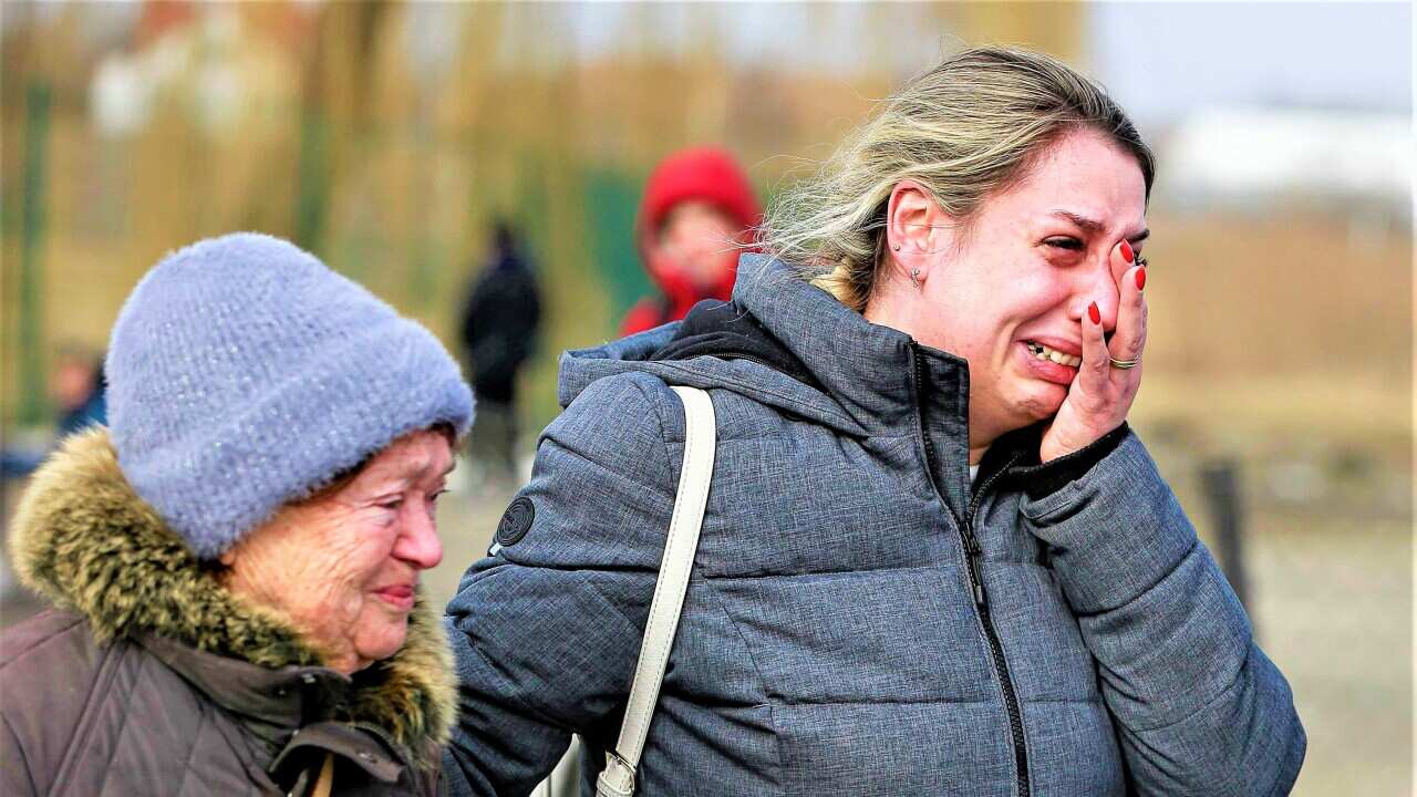 A Ukrainian woman reacts after arriving at the Medyka border crossing, in Poland, Sunday, Feb. 27, 2022.