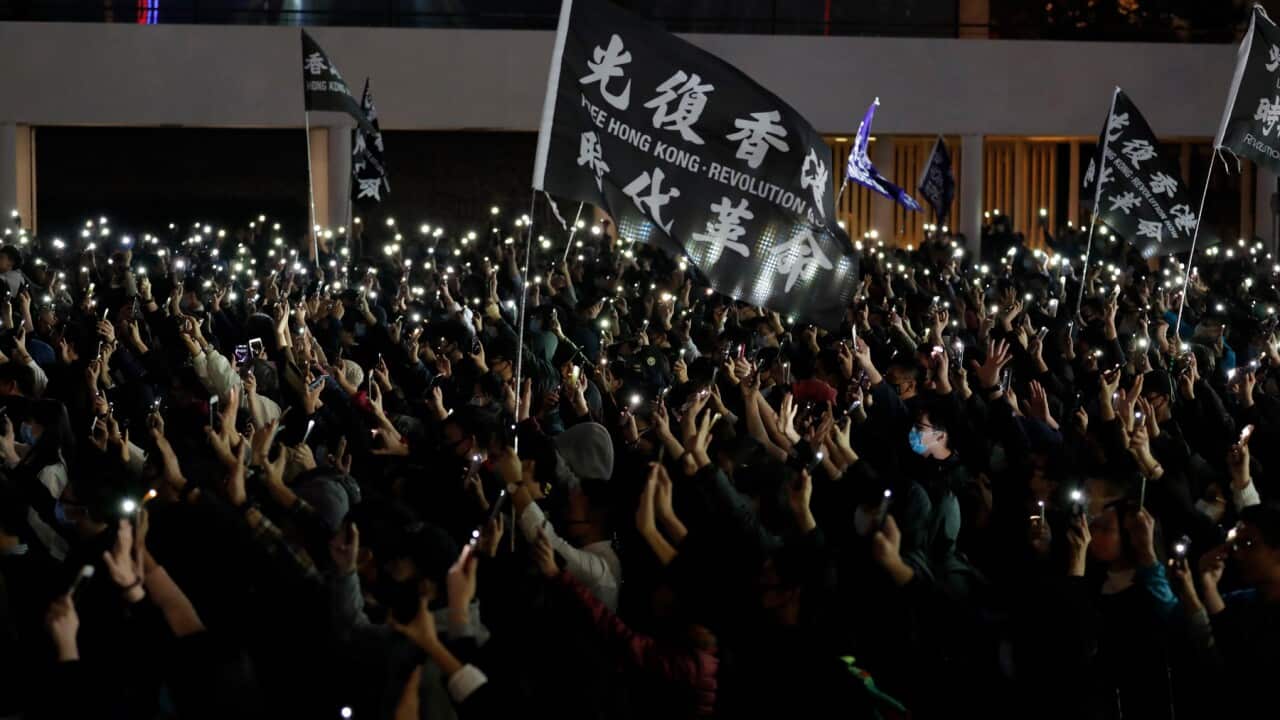Protesters hold up their smartphone lights and their hands to symbolize the five demands of the pro-democracy movement