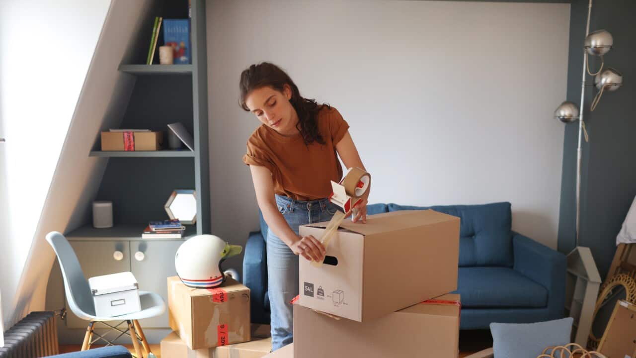 SG Moving Interstate - A young woman is packing her moving boxes