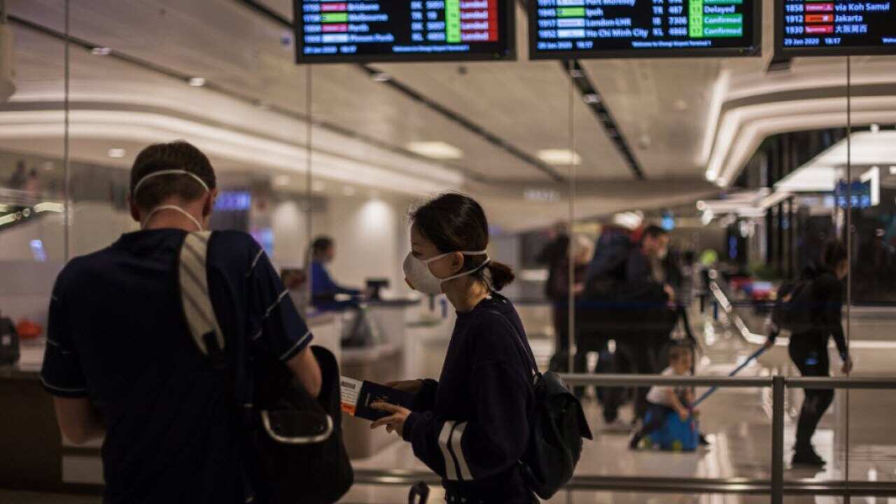 People wearing protective surgical masks at Changi Airport in Singapore.