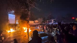Street scene in Iran with protestors standing around burning objects