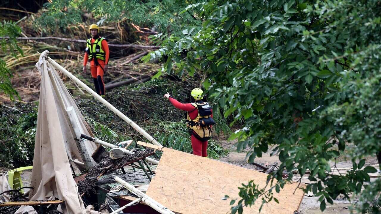 Rescuers stand in a flooded and damaged campsite as storms and heavy rains sweep across France. 