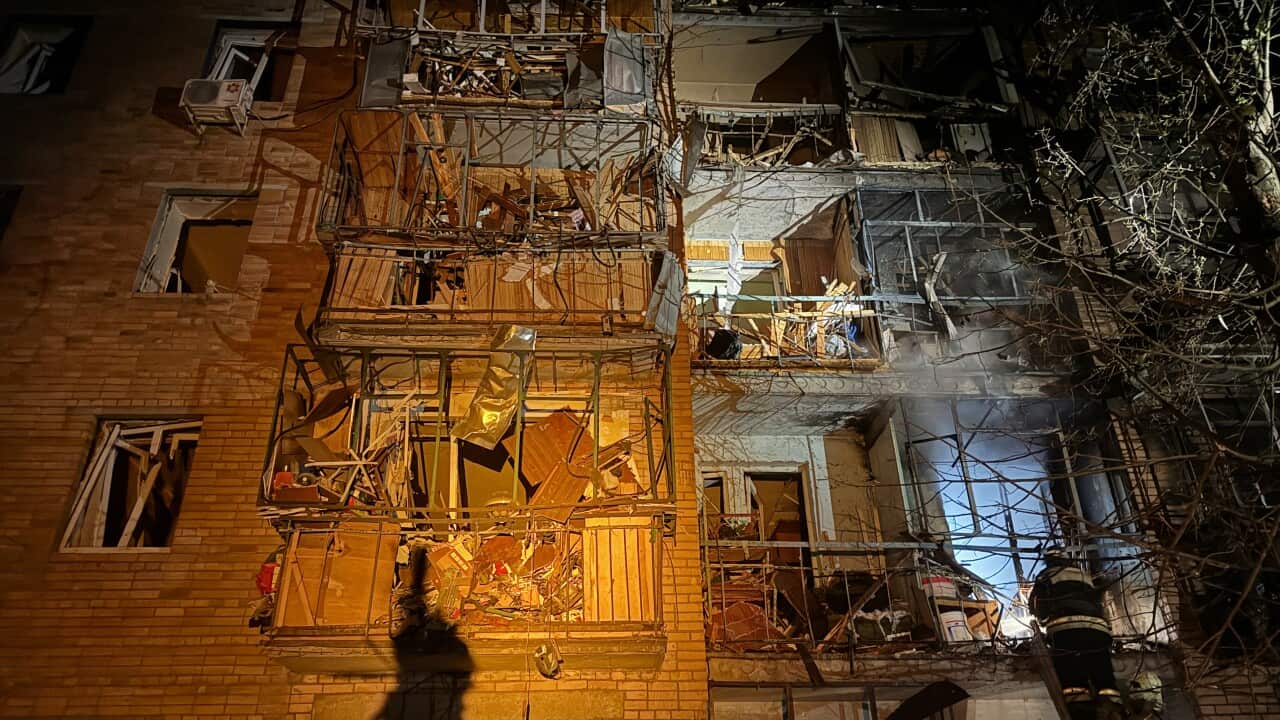 A damaged building with boarded up windows
