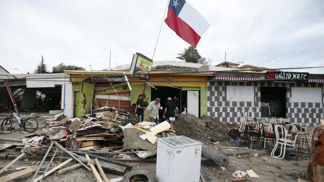 group of Chileans remove debris after strong waves in the aftermath of a 8.3 magnitude earthquake that struck northern Chile, in port city of Tongoy, Chile