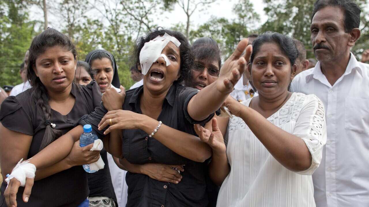Anusha Kumari, center, weeps during a mass burial for her husband, two children and three siblings, all victims of Easter Sunday's bomb attacks, in Negombo